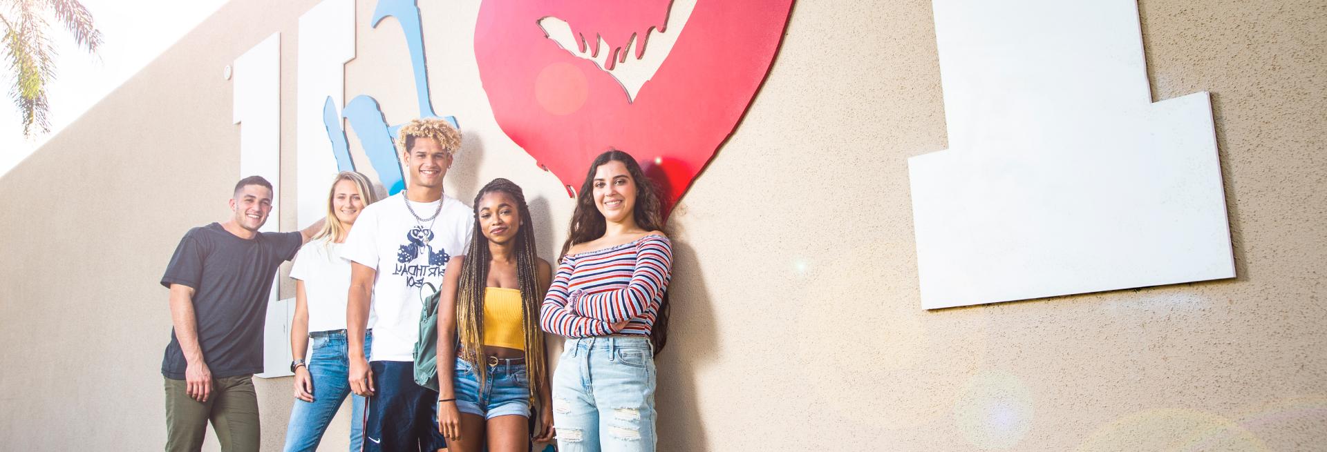 Students standing next to a wall